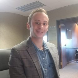 Picture of a man behind his desk smiling