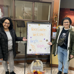 Voice Coaches clients Hazella and Valerie stand next to sign celebrating their demo day